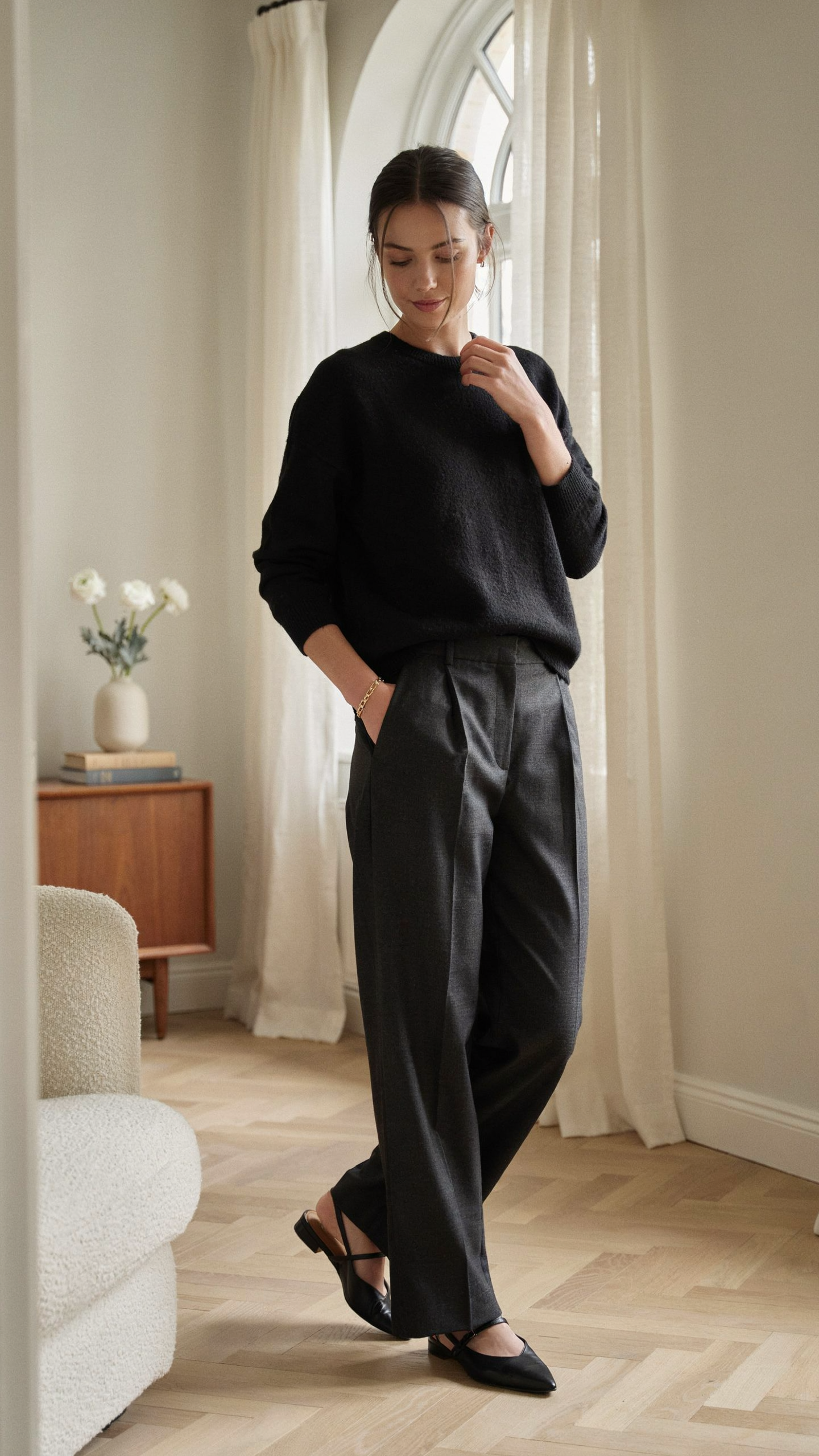 Elegant all black outfit featuring a cashmere sweater and wide leg trousers in old money style